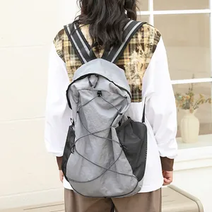 Mochila casual de nailon gris con cordón elástico y bolsillos laterales de malla para uso diario