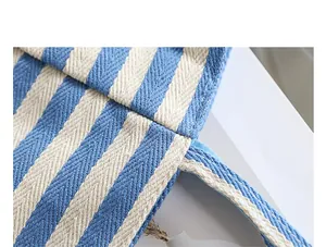 Close-up detail of blue and white striped canvas tote bag showing fabric texture.