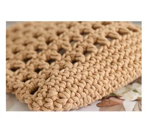 Macro detail shot showing the intricate texture of a handmade woven cotton rope bag.