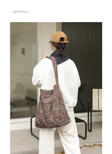 Détail du sac à bandoulière en toile marron avec broderie cachemire blanche