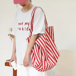 Bolso tote grande de lona a rayas rojas y blancas para mujer en un entorno informal