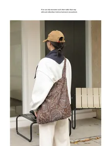 Sac bandoulière décontracté en toile marron avec motifs paisley brodés sur mannequin