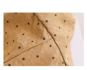 Makro-Detailaufnahme einer braunen Segeltuch-Einkaufstasche mit Polka-Dots und Nähten