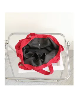 Detailed view of the red canvas tote bag interior showing black lining and zip pocket.