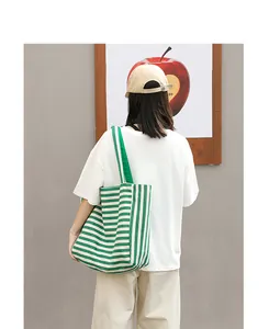 Detail view of a green and white striped canvas tote bag for casual everyday wear.