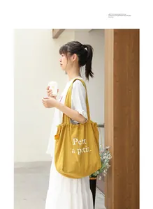 Detalle de bolso tote de lino amarillo con estampado blanco Petit à petit