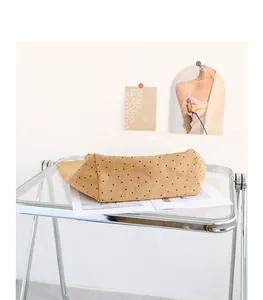 Detailed bottom view of a khaki polka dot canvas tote bag on a table