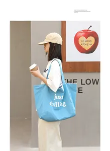 Close-up detail of blue nylon tote bag featuring a stylish just chilling printed message
