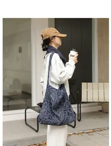 Photo de mode d'une femme portant un sac en toile bleu marine à motifs paisley élégants