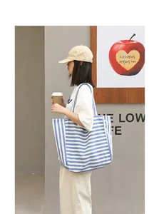 Large blue and white striped canvas tote bag for women in a casual street style