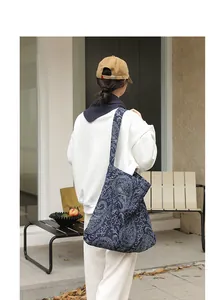 Vue détaillée d'un sac en toile bleu à motif cachemire porté par un mannequin.