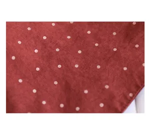 Macro view of high-quality burgundy canvas fabric with white polka dots and texture