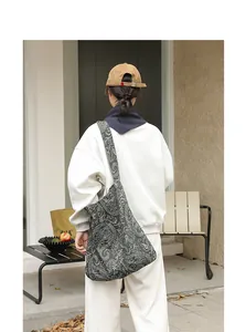 Vue détaillée d'un sac bandoulière en toile pour femme avec motif paisley blanc