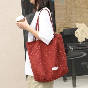 Artistic Japanese style red polka dot canvas tote bag shown on model in lifestyle setting