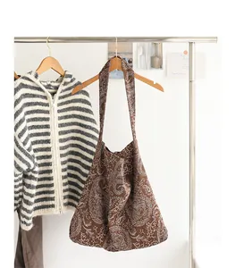 Vue détaillée d'un sac bandoulière japonais en toile marron avec motif cachemire sur portant