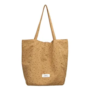 Minimalist artistic khaki polka dot canvas tote bag with white brand label detail