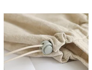 Primer plano de la hebilla gris con cordón en un bolso tote de algodón y lino beige.