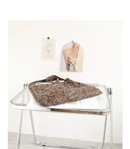 Gros plan d'un sac en toile marron avec broderie cachemire blanche sur un plateau