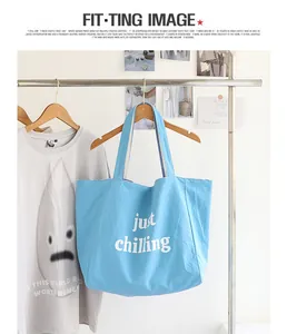 Light blue nylon tote bag with 'just chilling' white letter print on a clothing rack.