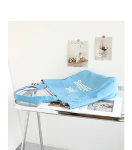Light blue nylon tote bag with white just chilling print in a casual lifestyle setting
