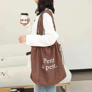 Elegante bolso de hombro de lino marrón con cordón e impresión 'Petit à petit'