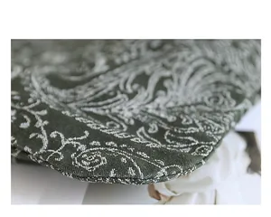 Gros plan sur le motif floral brodé vintage d'un sac en toile vert foncé