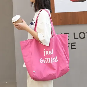 Moderno bolso tote de lona rosa con el eslogan 'just chilling' y forro interior de rayas