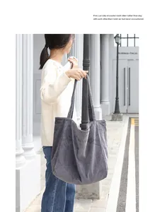 Detalle del bolso shopper de pana gris con bordado llevado por una modelo urbana