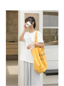 Bolso cubo de lona amarillo vintage con estampado de letras en ambiente lifestyle
