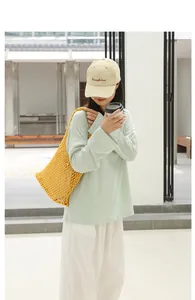 Modern yellow woven mesh shoulder bag shown in a casual lifestyle outdoor setting.
