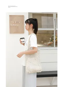Close-up of lifestyle model carrying a handmade cotton woven mesh beach shoulder bag