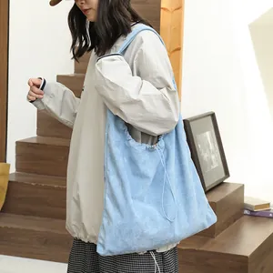 Stylish light blue suede drawstring shoulder bag with a casual slouchy fashion design