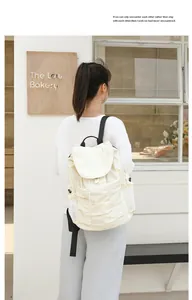 Mochila informal de nailon beige con diseño plisado en una escena al aire libre