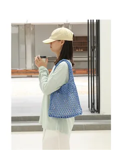 Handmade stylish blue cotton woven mesh shoulder bag for women in a lifestyle setting.