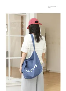 Back view of a model wearing a stylish blue casual nylon shoulder bag with letters