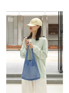 Detailed lifestyle shot of a blue hand-woven cotton mesh hollow-out shoulder bag