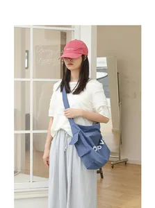 Blue nylon crossbody bag with side pocket shown on model in minimalist setting