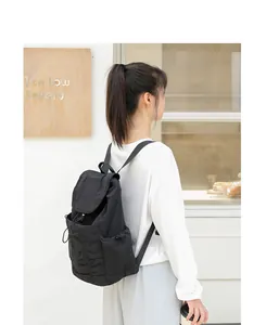 Mochila casual de nailon negro con diseño plisado, solapa y cierre de cordón ajustable