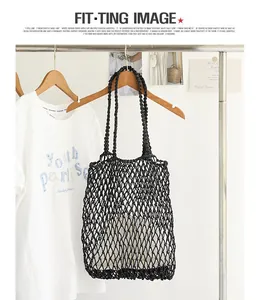 Close-up of a black woven macramé net beach bag hanging on a clothes rack