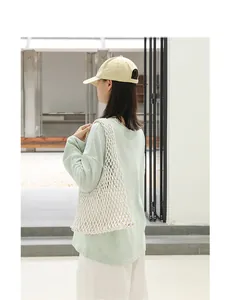 Model wearing a white cotton rope woven mesh underarm bag with minimalist outfit