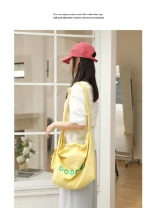 Lifestyle detail of a casual yellow canvas crossbody bag featuring a knotted strap design