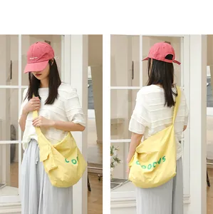 Close-up of a casual yellow crossbody bag worn by a model in a shop setting