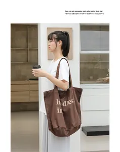 Vista detallada del bolso de lona vintage marrón con estampado de letras para mujer