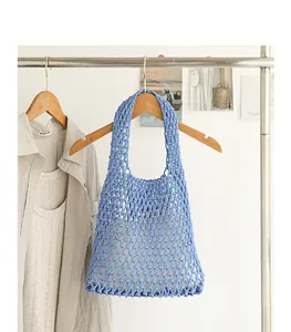 Handmade blue cotton woven mesh bag with hollow out design on a wooden hanger