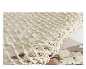 Detailed view of the hand-woven cotton macrame mesh bag with a soft drawstring inner pouch