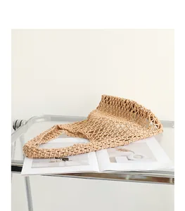 Detailed view of a hand-woven cotton mesh shoulder bag on a minimalist glass shelf.