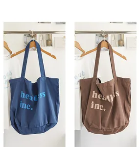 Comparación de bolsos tote de lona lavada en azul y marrón con estampado de letras