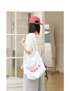 Stylish white canvas crossbody bag with red letter print and knotted strap detail