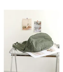 Primer plano de un bolso de lona verde lavado sobre una mesa de acrílico moderna