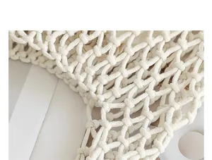 Macro detail of hand-woven off-white cotton mesh bag showing intricate knotting